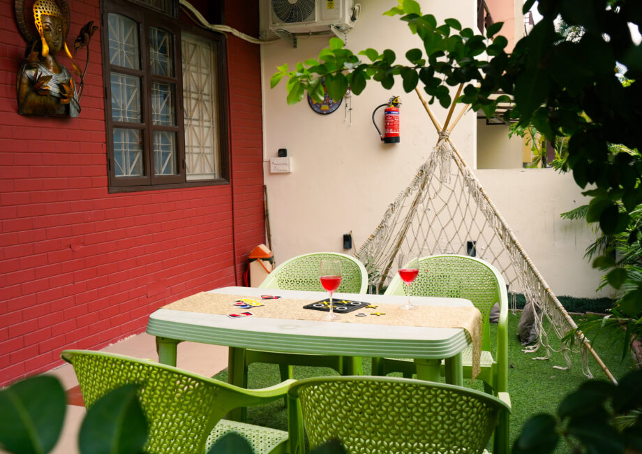 Outdoor bistro table and chairs near red brick wall and Buddha art
