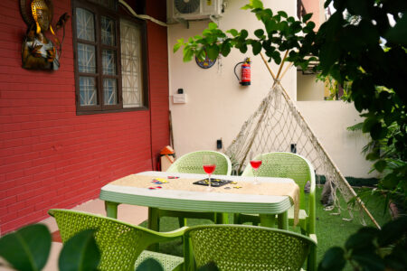Private garden patio beside the room with table setting, macramé teepee and red brick wall Ground Floor Haven, The Basera.