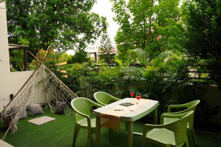 Garden lounge with hammock-style macrame teepee and chairs