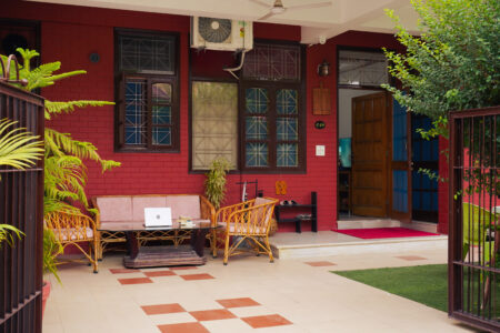 Front porch seating area at The Basera with rattan furniture steps from the Ground Floor Haven entrance.