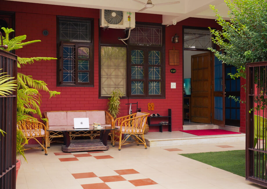 Front porch seating area at The Basera with rattan furniture steps from the Ground Floor Haven entrance.