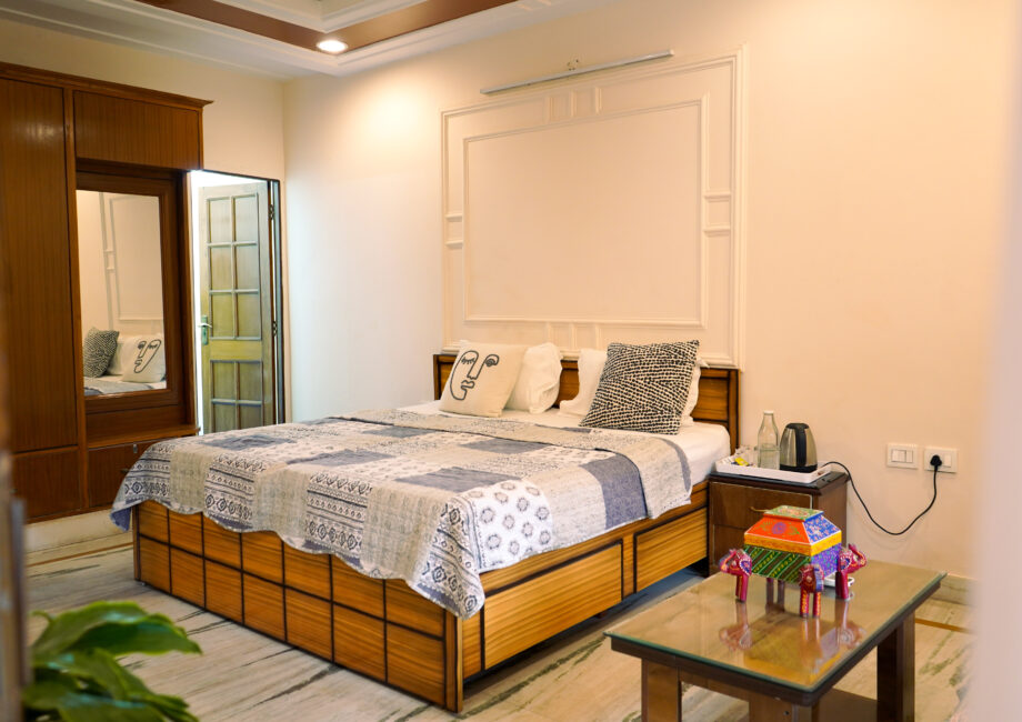 Ground Floor Haven bedroom with warm neutral décor, double bed, sofa, and garden-facing windows at The Basera Rishikesh.