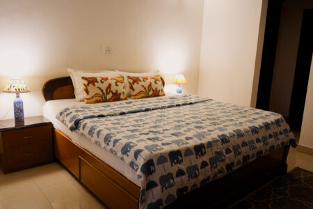 Harmony Suite king bed with patterned duvet, bedside lamps, and warm lighting