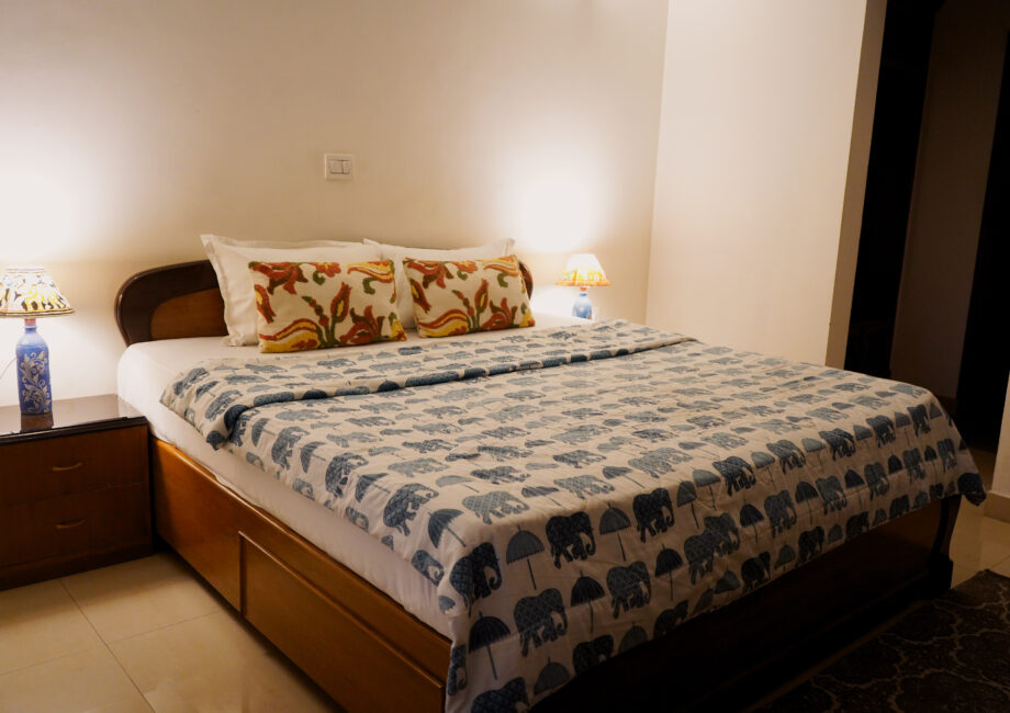 Harmony Suite king bed with patterned duvet, bedside lamps, and warm lighting