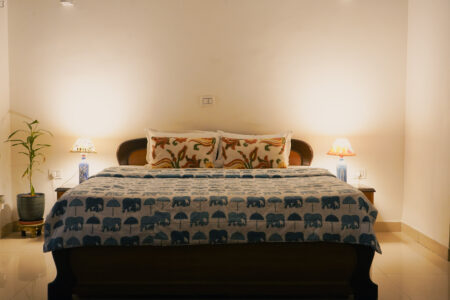 Close view of bed with patterned cushions and Indian traditional lamps