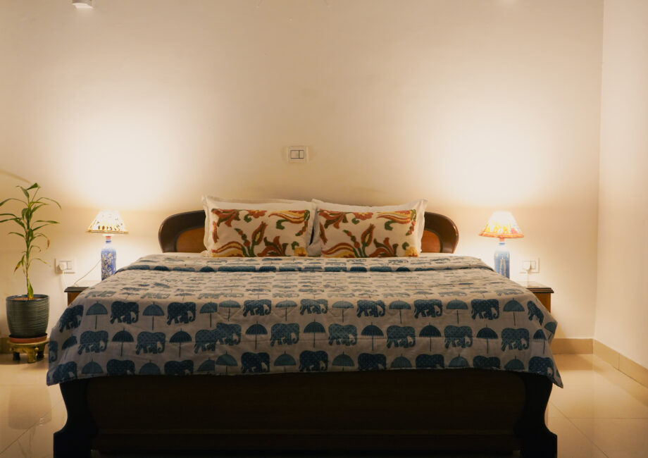 Close view of bed with patterned cushions and Indian traditional lamps