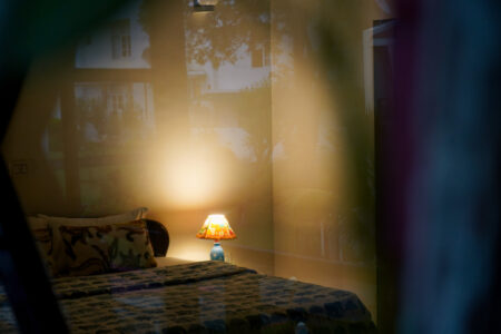 Artistic elephant-themed bedside lamp softly illuminating a cozy bedroom corner at The Basera