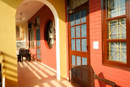 Shared balcony corridor with brick arches and seating
