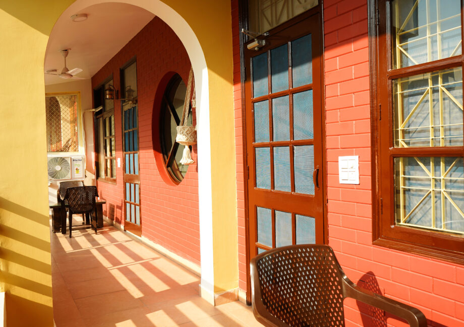 Shared balcony corridor with brick arches and seating