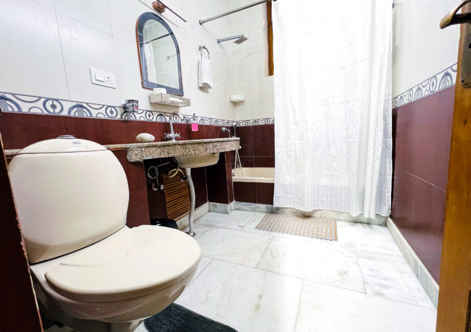 Ensuite bathroom wide: toilet, granite vanity and shower curtain over tub