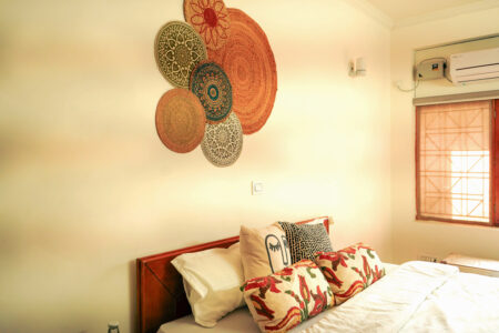 Close view of colorful cushions and woven bohemian decor above bed