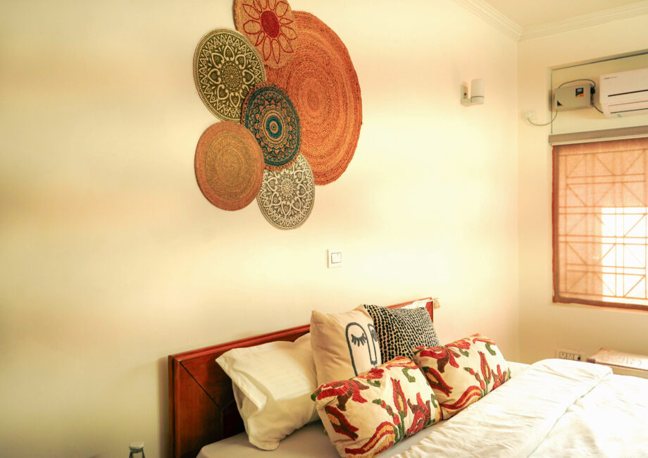 Close view of colorful cushions and woven bohemian decor above bed