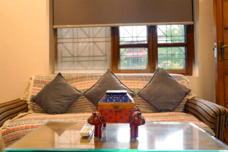 Sofa seating with handcrafted decor box and window light inside the Ground Floor Haven suite.