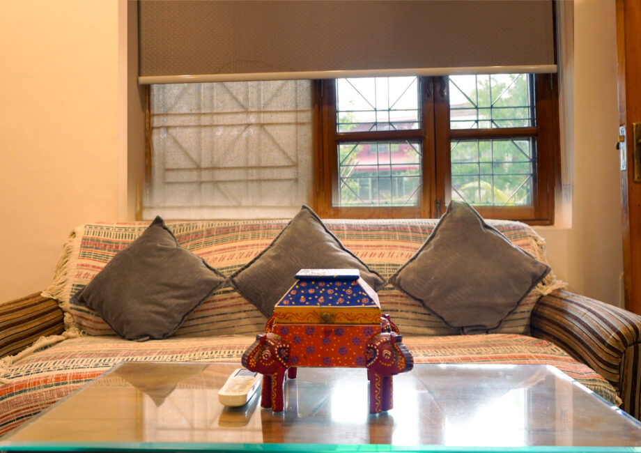 Sofa seating with handcrafted decor box and window light inside the Ground Floor Haven suite.