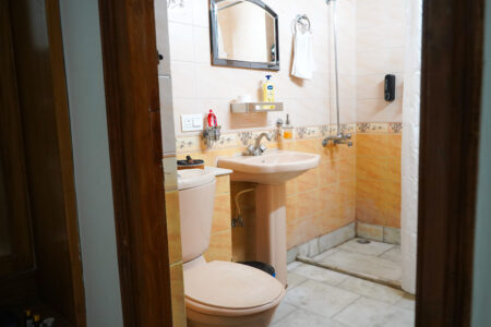 Clean private bathroom with toilet, washbasin, and essential toiletries in The Little Paradise.