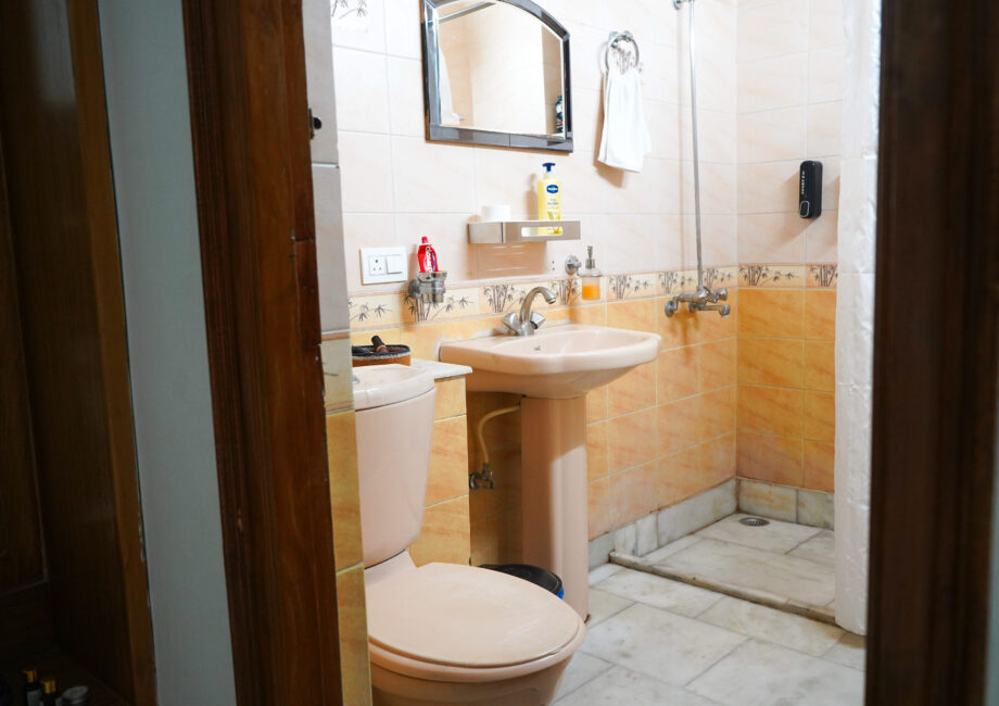 Clean private bathroom with toilet, washbasin, and essential toiletries in The Little Paradise.