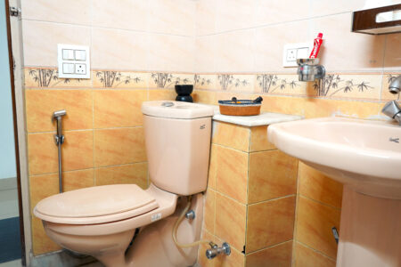 Compact bathroom with mirror, shower, and washbasin, designed for practical comfort.