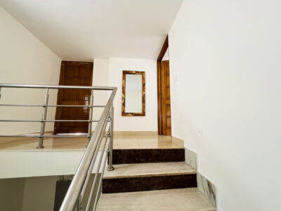 Spacious double bed with crisp white linens and tribal-print cushions at The Basera.