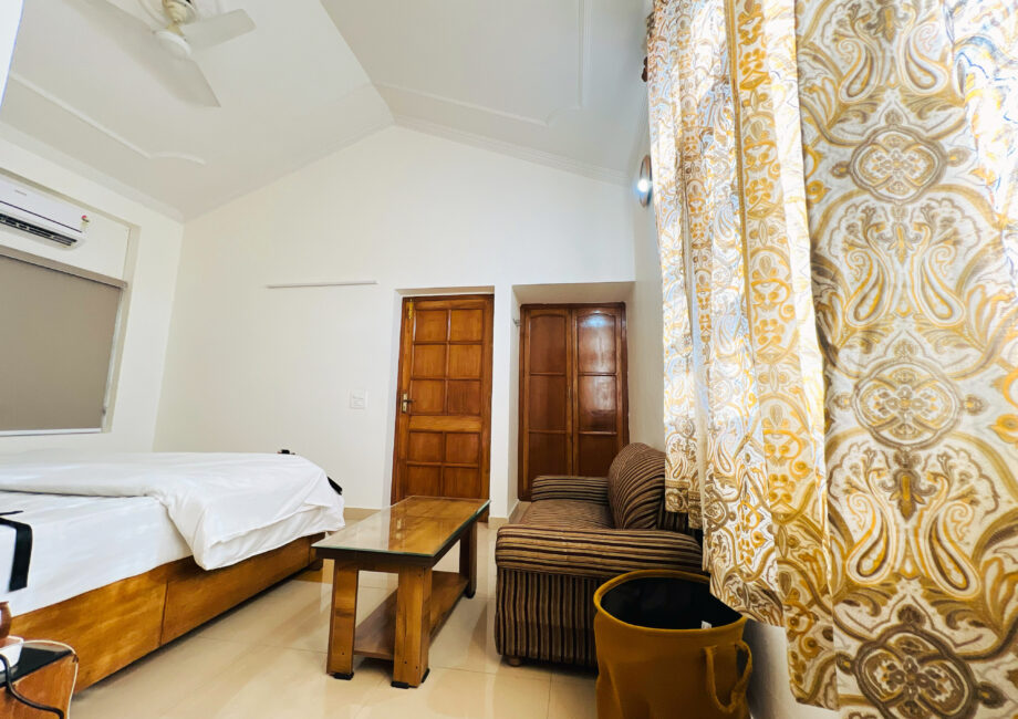 Cozy double bed with patterned cushions and warm natural light in The Little Paradise room.